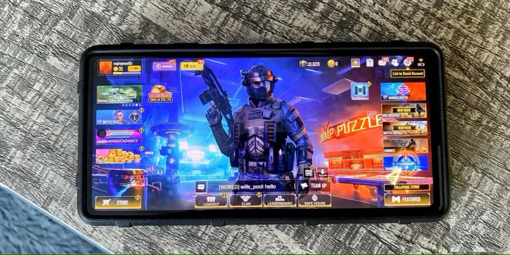 گوشی اندروید روی میز با صفحه اصلی بازی Call of Duty Mobile نمایش داده می شود